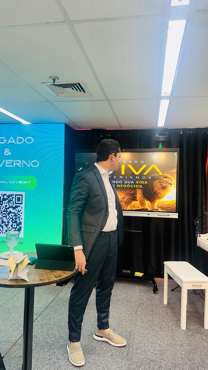 Gustavo Coelho de perfil diante de telão com a arte Imersão Aviva Experience